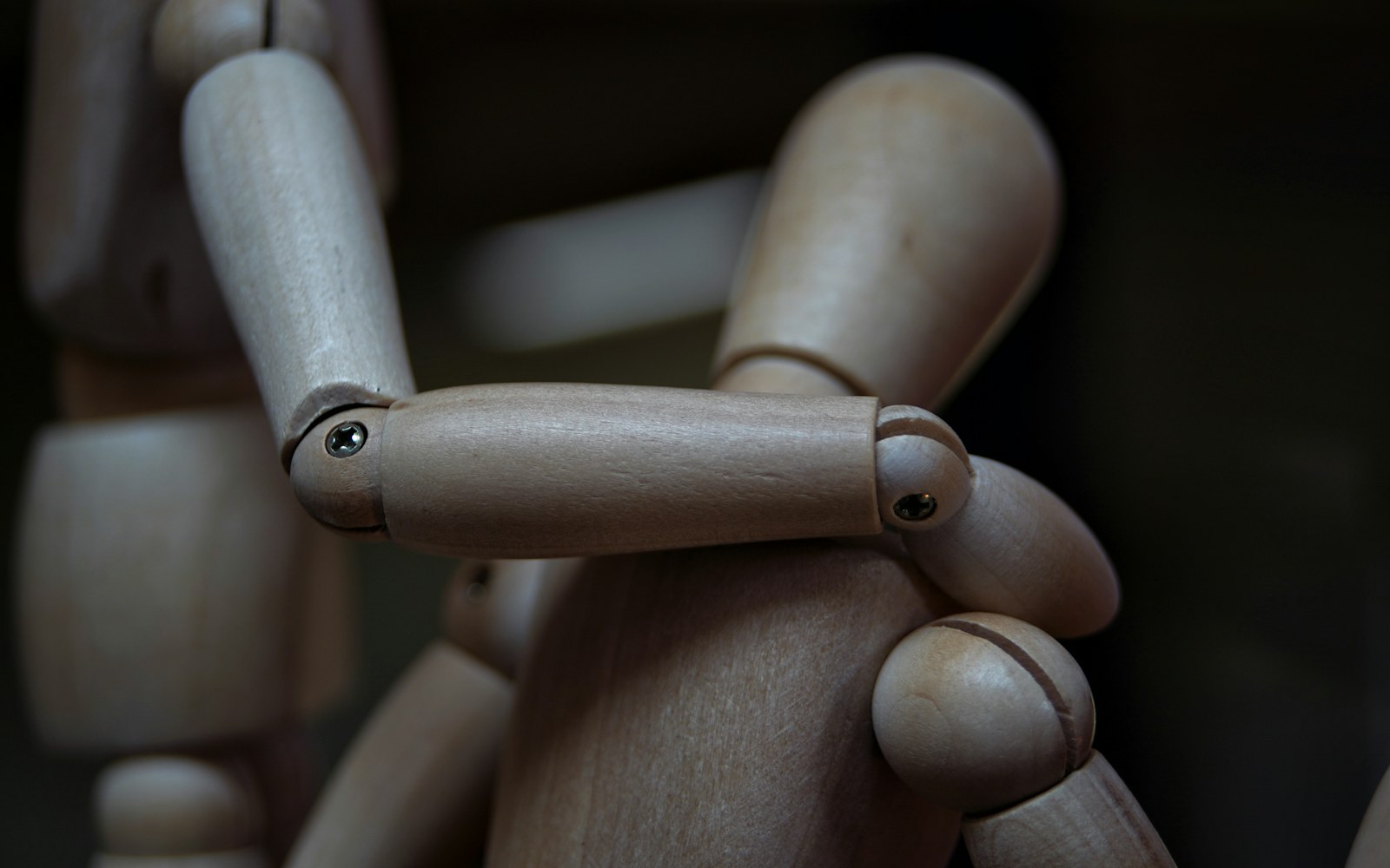 A worktable with a small handmade figure, wire, foil, foam, wood, and cardboard armature components