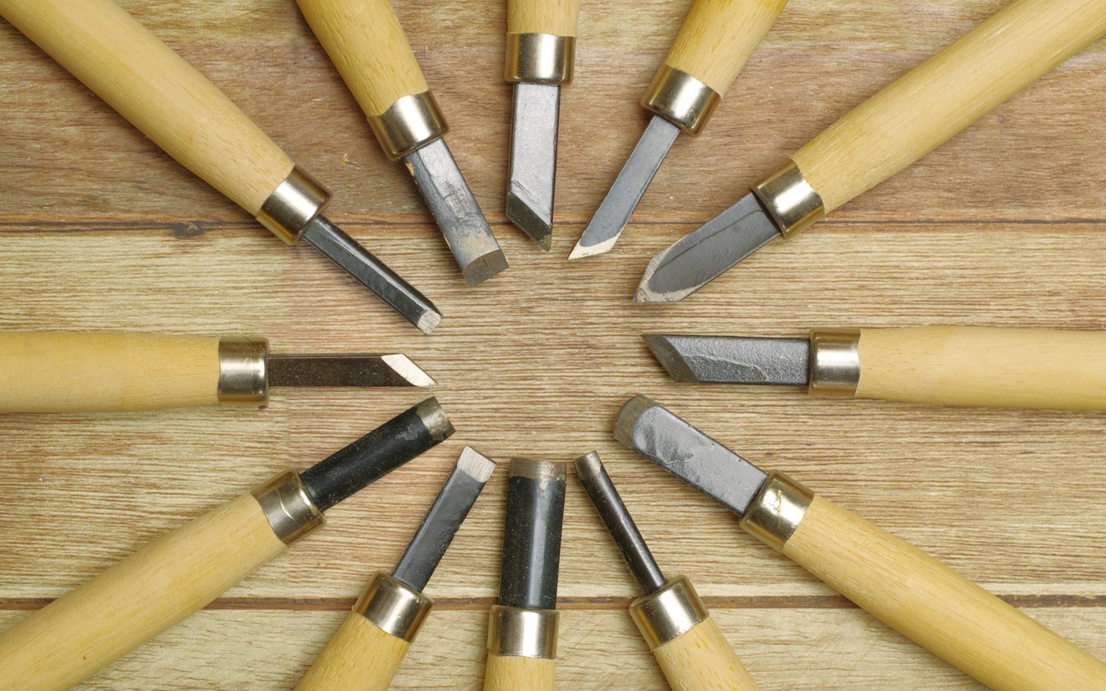 Small sculpting tools and three types of clay arranged beside a miniature art doll accessory