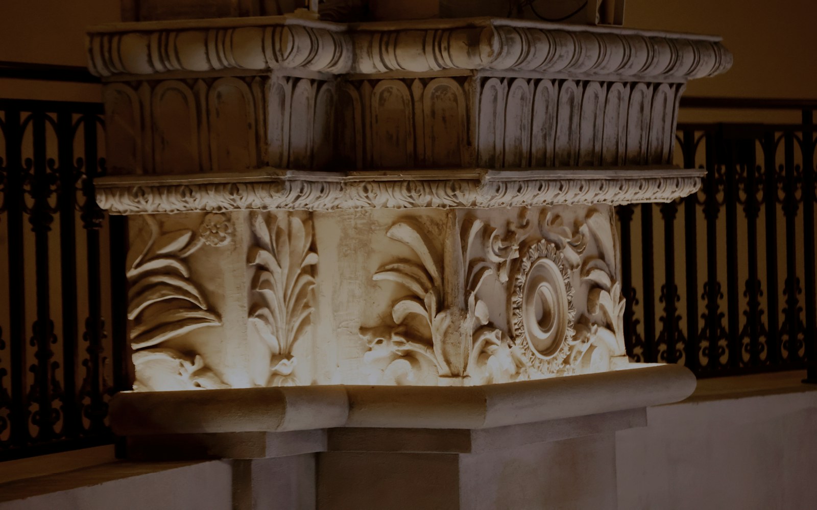 A large handmade figure resting on a broad, discreetly supported plinth in a bright interior