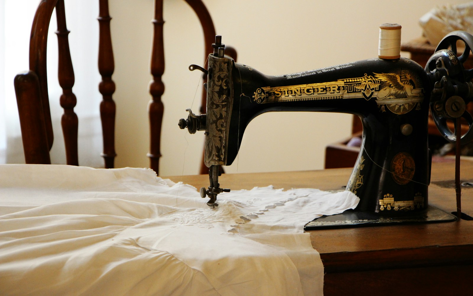 Pattern paper bodice pieces, a small muslin toile, pins, ruler, and fine sewing tools arranged beside an art doll torso.