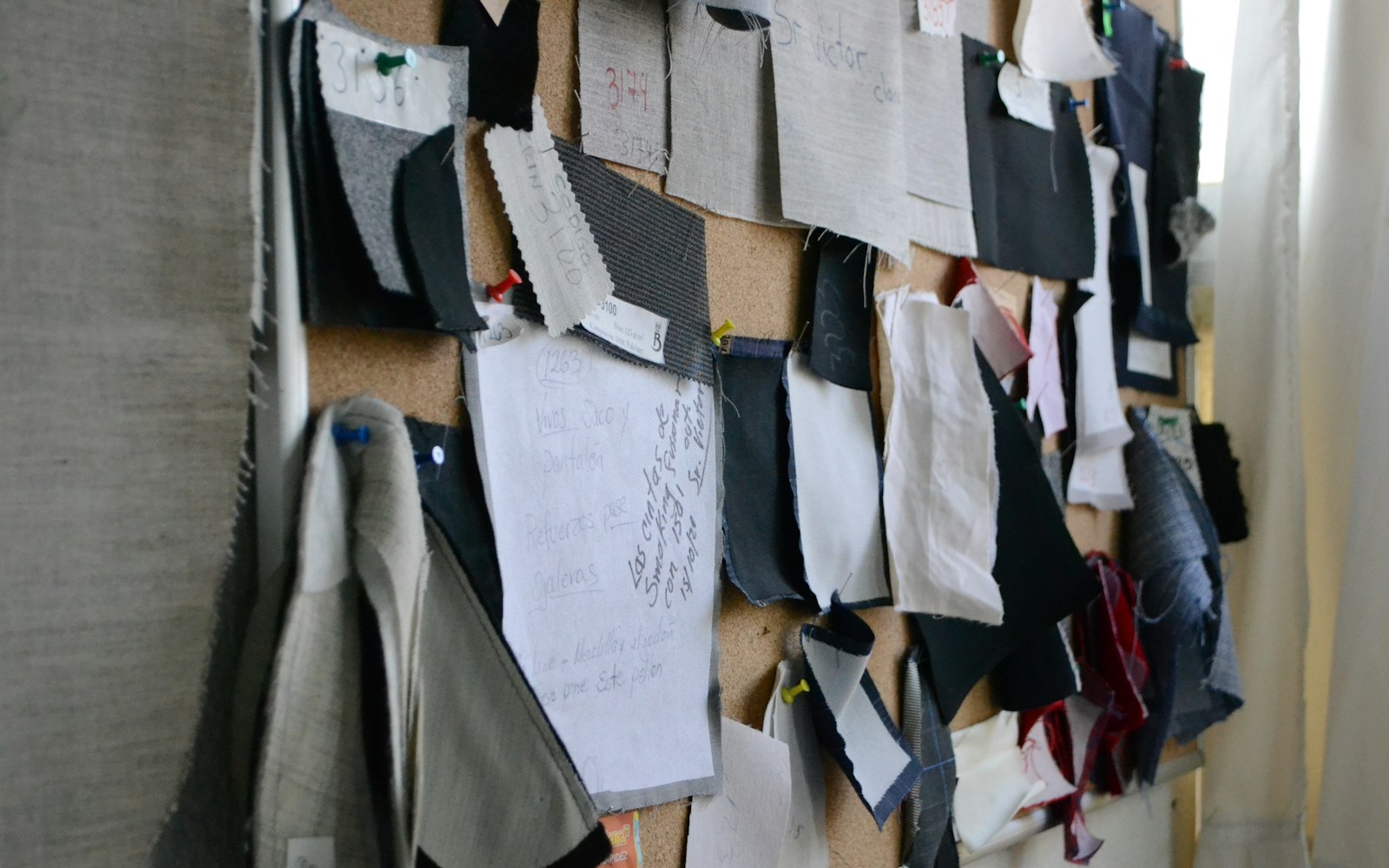 Small fabric swatches, fine scissors and a partially made art-doll garment arranged on a worktable