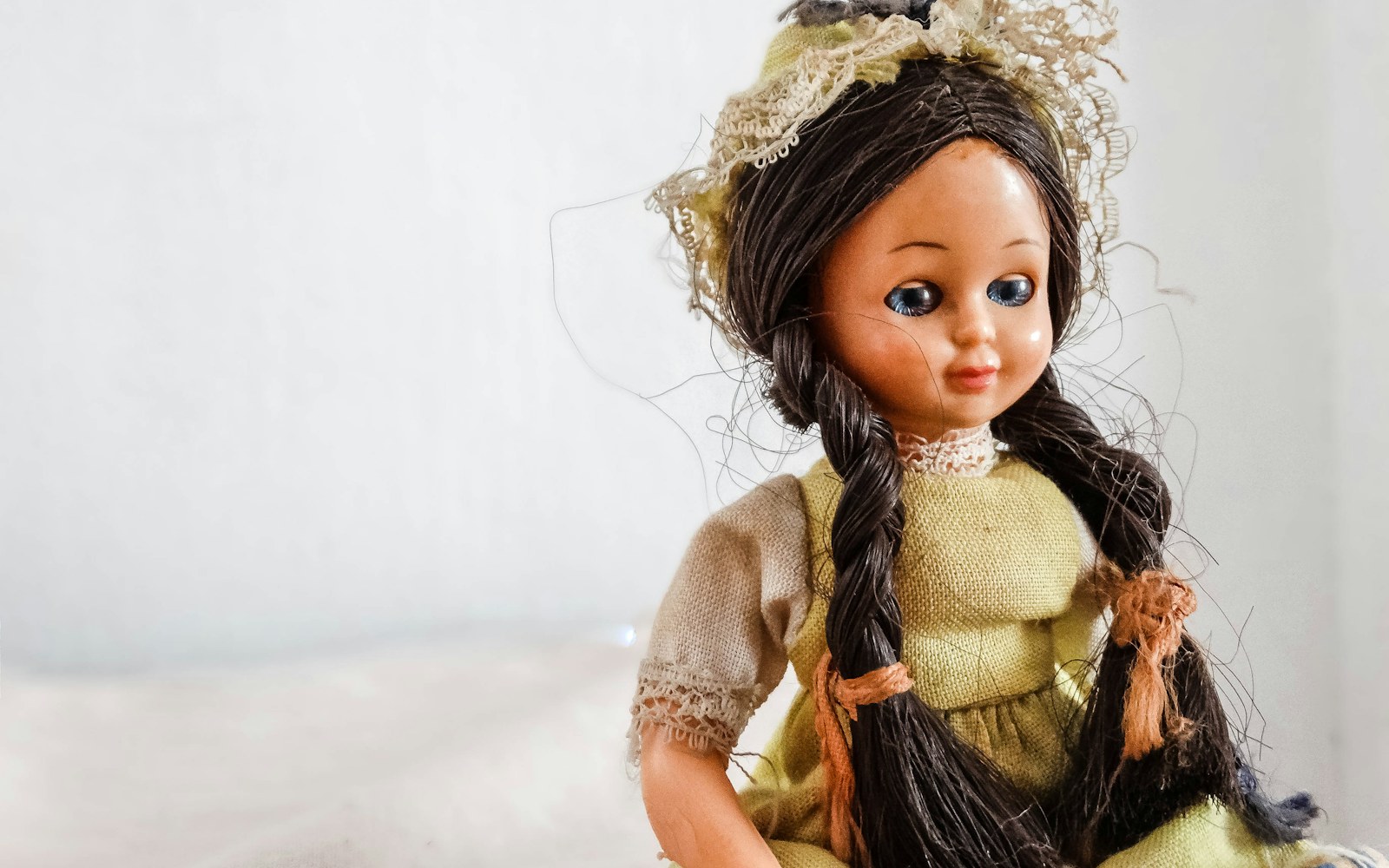 A collector’s worktable with a handmade art doll, archival notes, photographs, and labeled documents