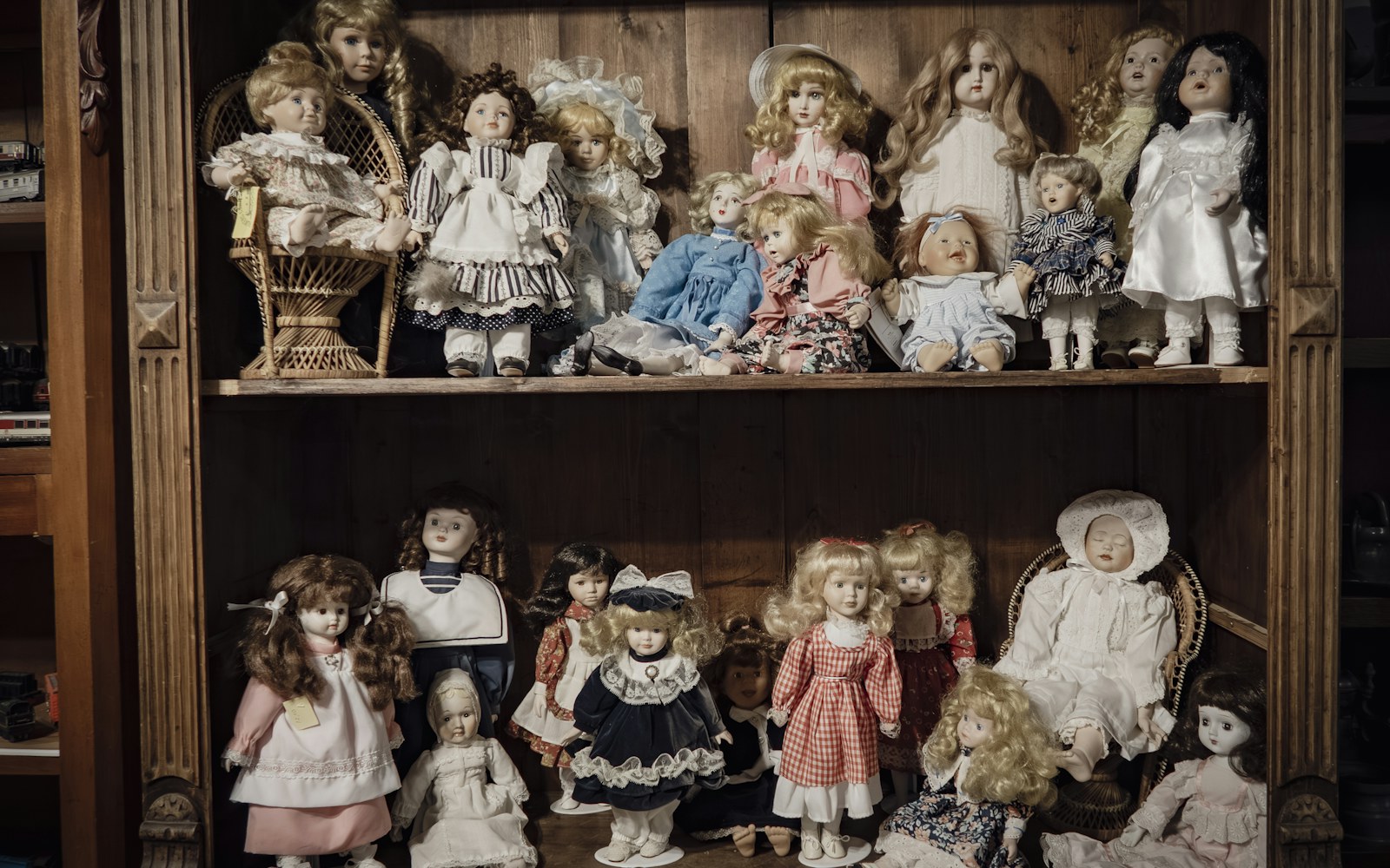 A handmade textile figure displayed on a stable shelf inside a clear protective case away from direct sunlight