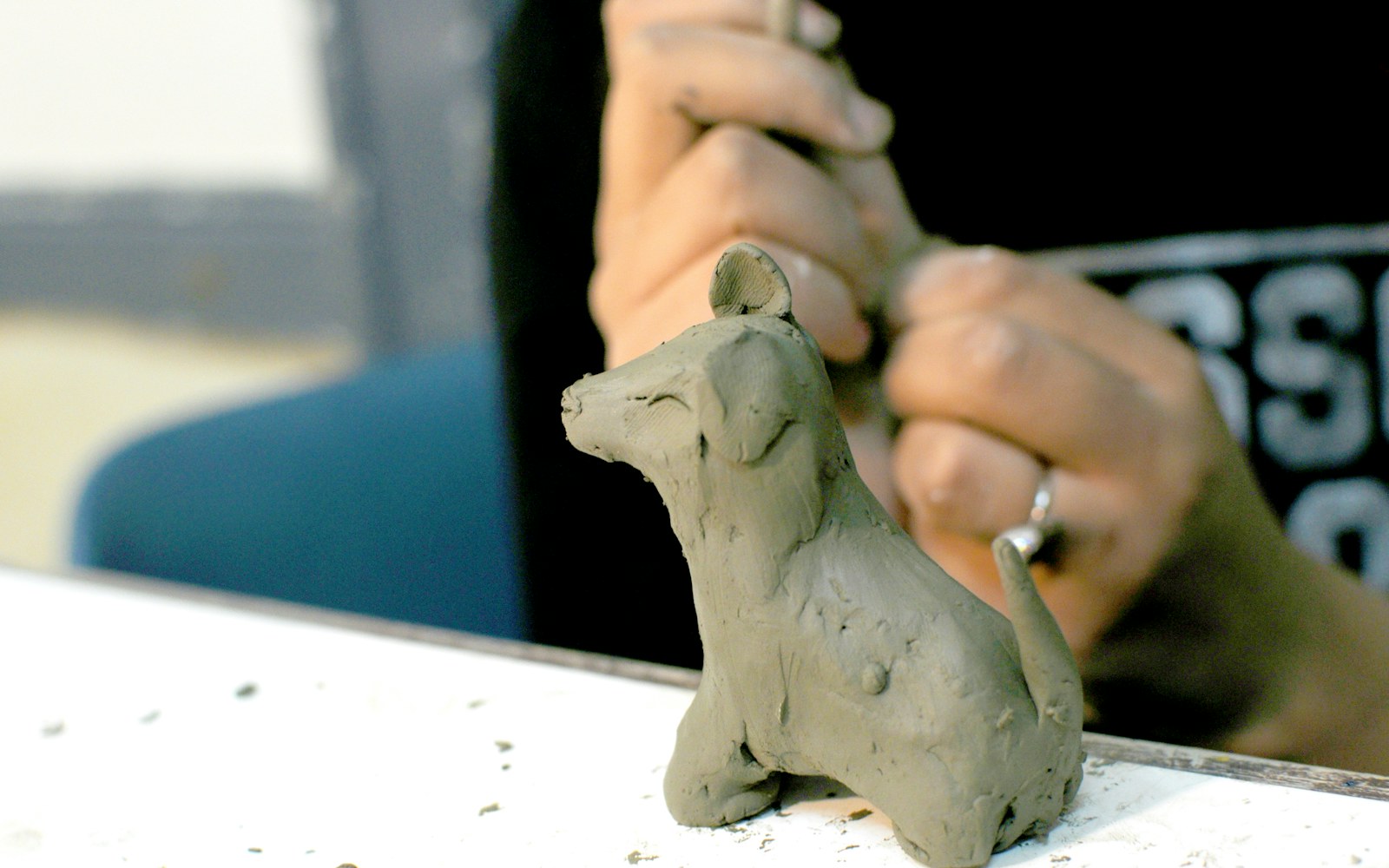 Small painted air-dry clay accessories arranged beside an art doll on a clean worktable