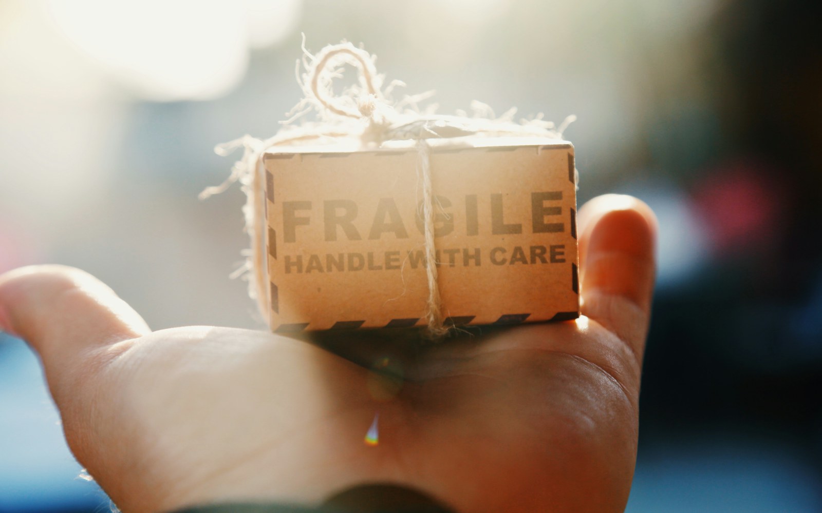 A carefully packed handmade art doll in a fitted box with white tissue barriers and shaped cushioning around its head and limbs.