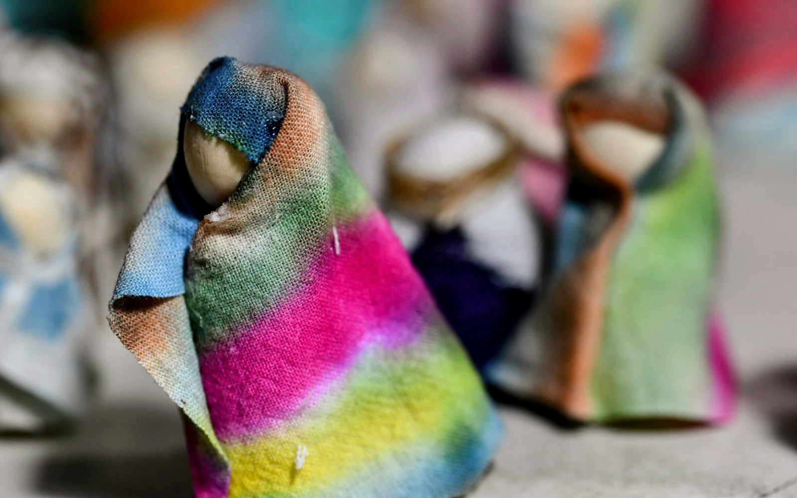 A painted air-dry clay figure beside small brushes and sample sealer surfaces on a clean worktable