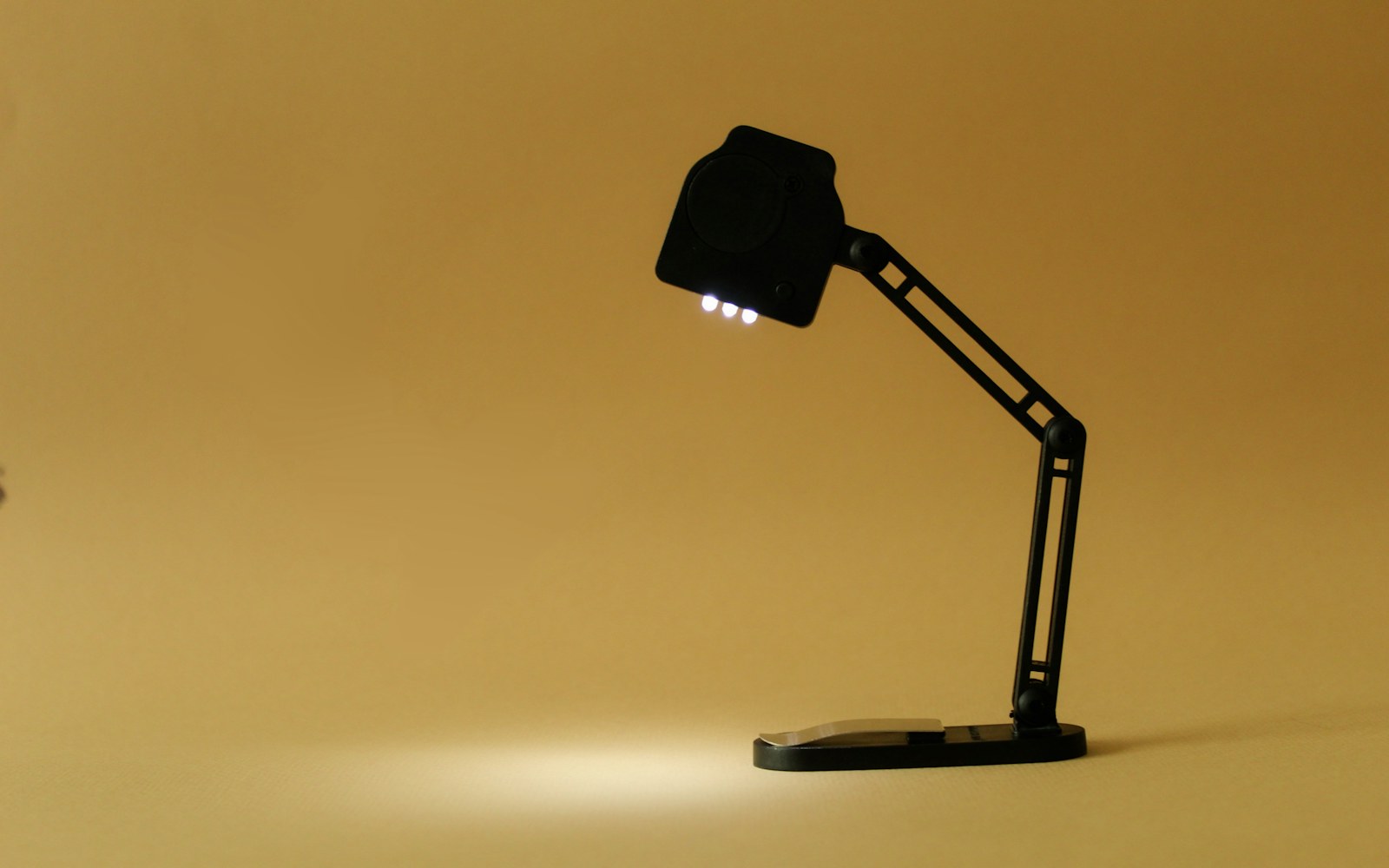 A handmade miniature lamp beside an art doll, shown with a discreet battery compartment and softly diffused warm LED light.