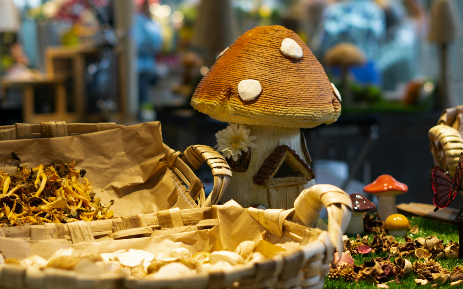 Handmade miniature pastries, cups, plates, and a wooden serving tray arranged beside a small art doll on a worktable