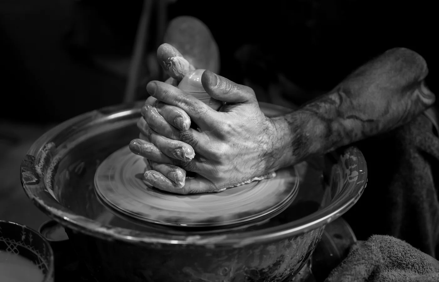 Hands shaping clay on a pottery wheel.