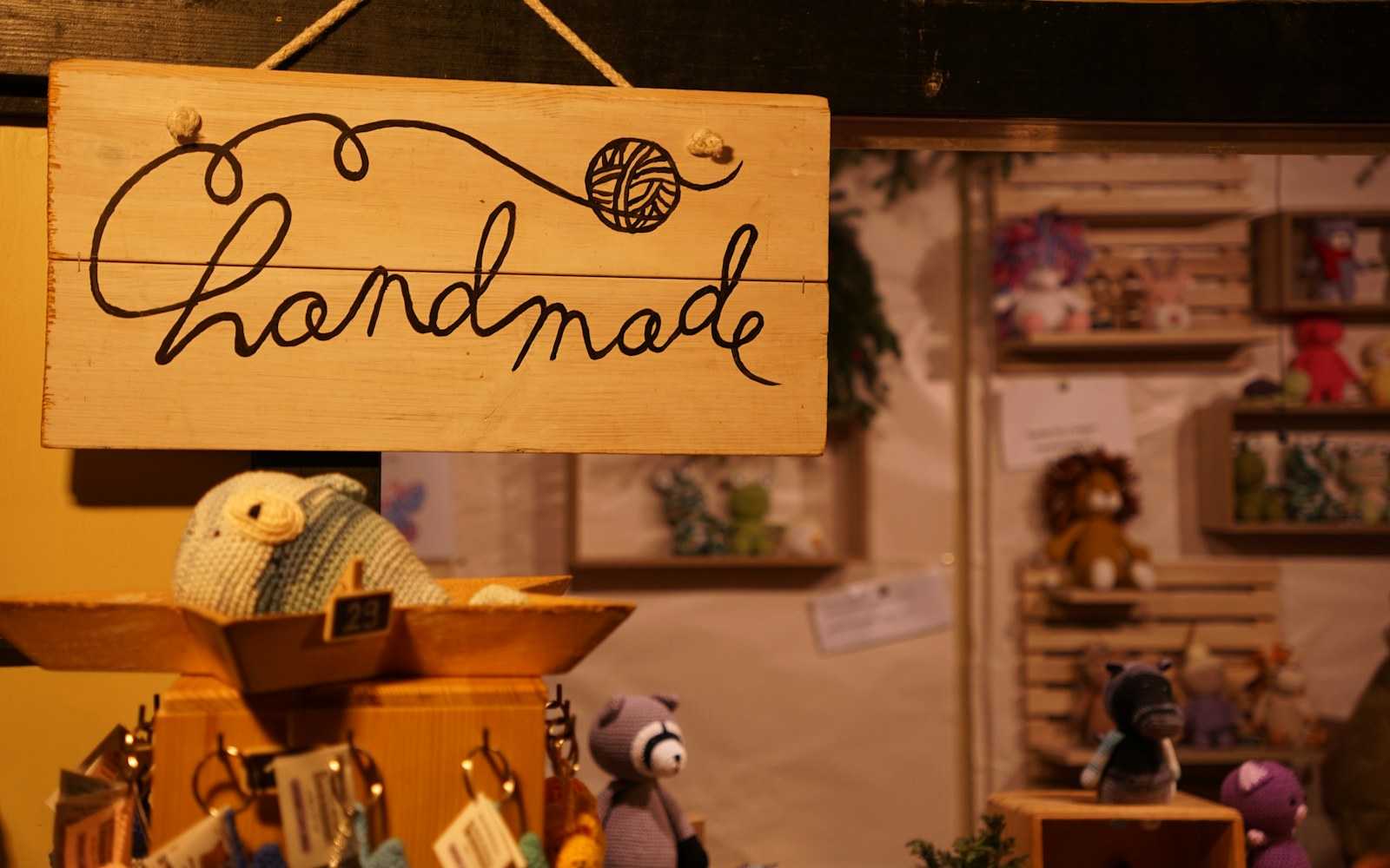 A handmade art doll beside a notebook, photographs, fabric samples, and labelled archival folders on a studio table