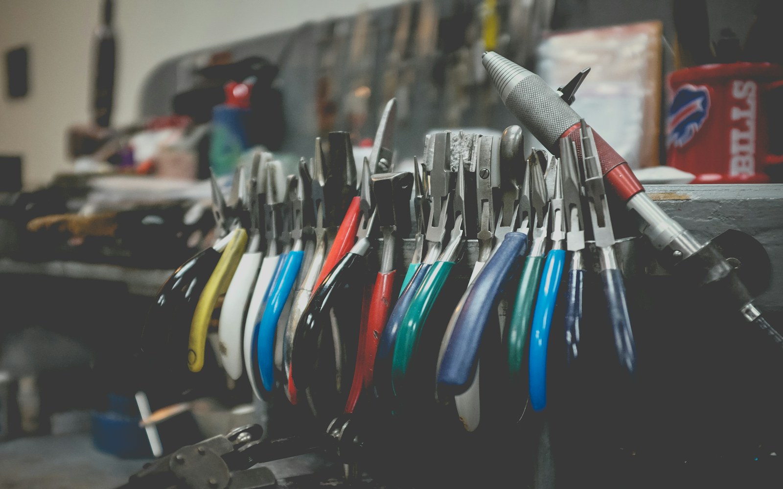 Close view of wire armature limbs, padded torso sections, pliers, and fabric on a maker's worktable.